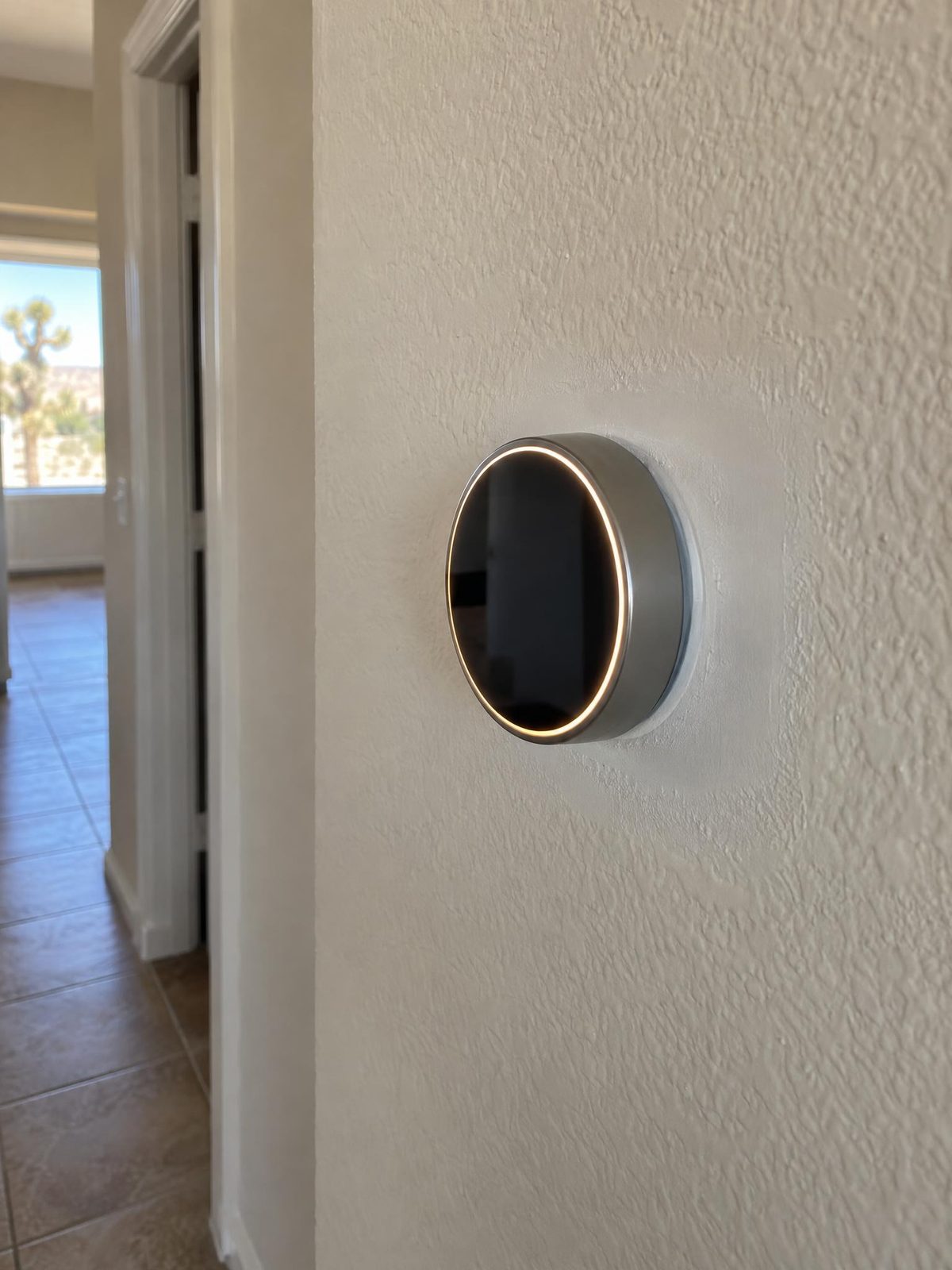Newly installed smart thermostat on a hallway wall